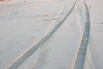 Off road tire tracks on sand in outskirt of town