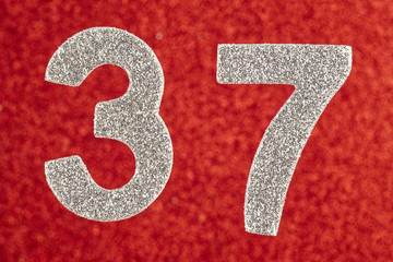 Number thirty-seven silver color over a red background. Anniversary