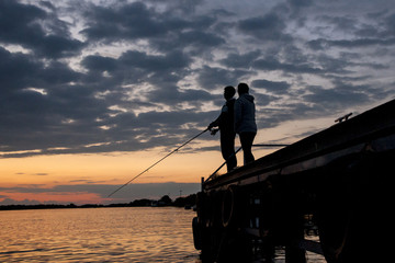 Silhouette of fishermen in beautiful sunset