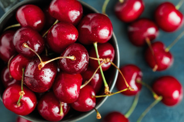 Top view of a bowl with ripe cherry over blue background. The concept of healthy organic food.