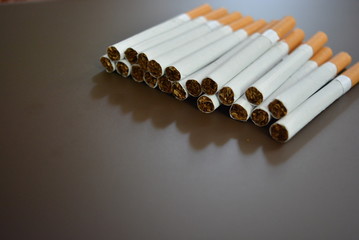 Cigarettes lying in a bunch on a brown matte background