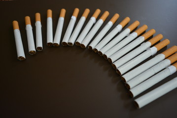 Cigarettes are lined on a brown matte background