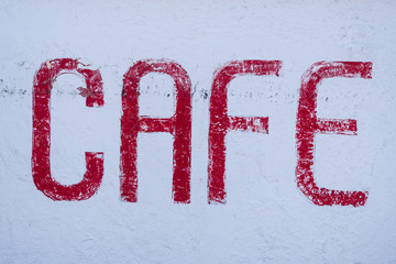 Cafe word painted in red on a white wall