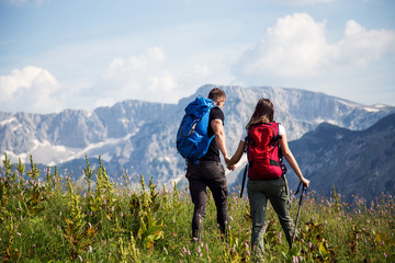 Obraz premium Young couple with backpacks walking on mountain
