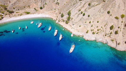 Aerial birds eye view photo taken by drone of famous tropical rocky beach of Agios Georgios with yachts docked, Symi island, Dodecanese, Greece