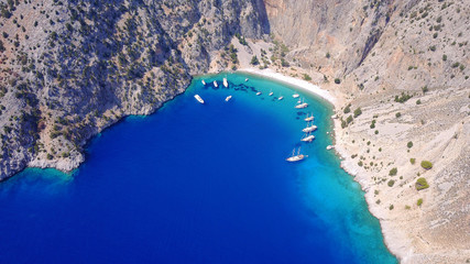 Aerial birds eye view photo taken by drone of famous tropical rocky beach of Agios Georgios with yachts docked, Symi island, Dodecanese, Greece