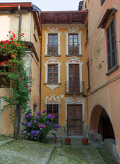Fototapeta na wymiar summer image of an ancient village with flowers on the facades of houses, Italy