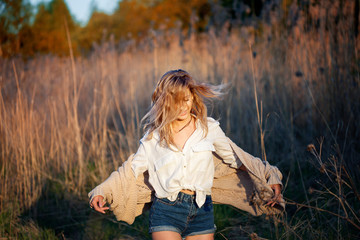 Girl is running out. Young woman in field, feel freedom and happiness. Casual style.