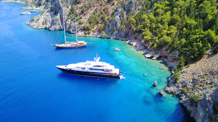 Fototapeta na wymiar Aerial birds eye view photo taken by drone of famous tropical rocky beach of Nannou with yachts docked and clear turquoise waters, Symi island, Dodecanese, Greece