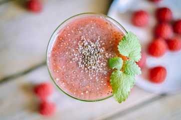 Raspberry smoothie in a glass on wooden table