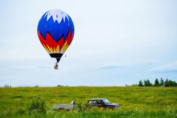 Bright colorful hot air balloon flying over field © smspsy
