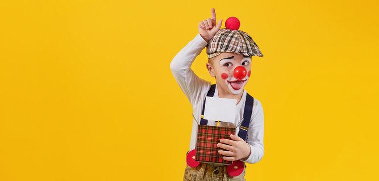 Funny kid boy clown fooling isolated yellow background,studio,blank,copy space for text,design,,advertising. Concept holiday,birthday,day laughter,jokes,1 april,party. Expression child face joy,smile.