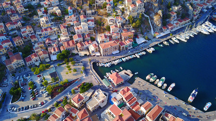 Obraz premium Aerial birds eye view photo taken by drone of Yalos, iconic port of Symi island at sunset with beautiful clouds, Dodecanese, Greece