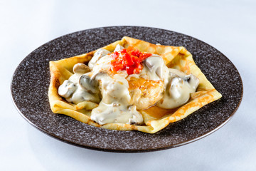 Delicious crepe with mushrooms, cutlet and pepper on light backg