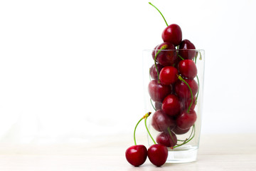 fresh cherries in glass for homemade cherry juice or smoothi. copyspace - sweet eating, dessert and food concept