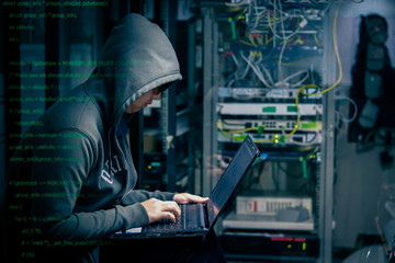 Internet crime concept. Hacker working on a code on dark digital background with digital interface...