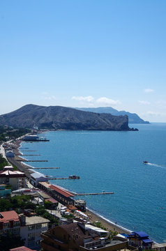 SUDAK, CRIMEA - June, 2018: View of the city beach from the walls of the Genoese fortress