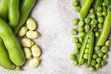 Fresh green peas and beans on light background