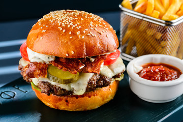 Tasty juicy burger with French fries in the cafe