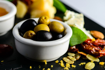Tasty cheese plate with olives