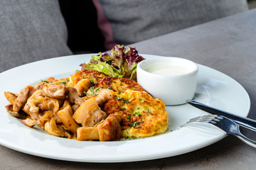 Tasty potato pancakes and delicious mushrooms on the plate. New 