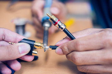 Closeup of soldering RCA cable, Repair and adjustment of the equipment, the RCA cable and pliers on the table
