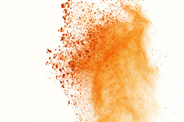 Explosion of colored powder on white background. Orange colored of dust explode on isolate background. Paint Holi. Colorful cloud splash.