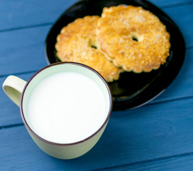 Large cup with milk and cookies in the background.