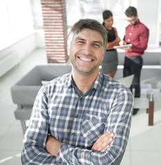 Smiling mature businessman in plaid shirt foreground