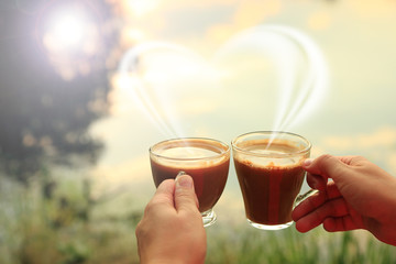 Dwie szklane filiżanki kawy w dłoniach kobiety przy zachodzie słońca. - obrazy, fototapety, plakaty