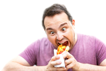 Hungry man with crazy eyes is eating hot dog isolated at white background.