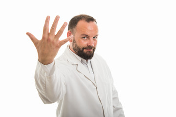 Portrait of male doctor showing number five with fingers