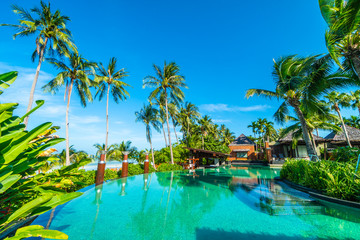 Beautiful outdoor swimming pool with coconut palm tree