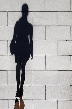 Long Shadow Of Aa Elegant Woman Walking On Pedestrian Street