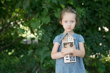 Green schooling. Girl holding insect hotel