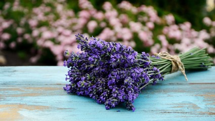 Bouquet of lavender on a blue old wooden table on the background of the garden.