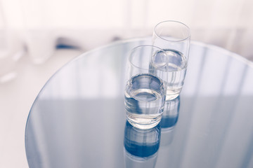 Two glasses of clean water on the glass table. Home.