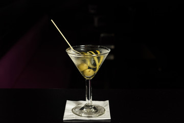 Classic glass of dry Martini with  olive and with a lemon twist, isolated.