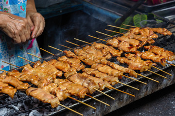 moo ping, grilled pork  skewer sticks on the bbq grill outdoor, Thai street food