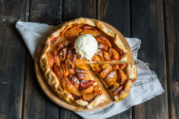  Homemade apricot galette made with fresh organic apricotes on wooden table, top view. Process of...
