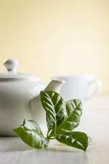 tea leaves on table with teapot and cup