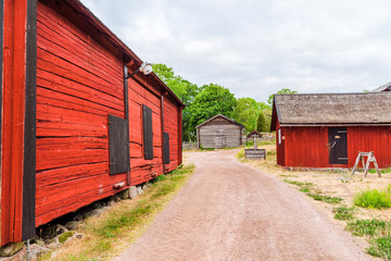 Vintage village well beside a gravel road and some barns. Homes in the background. Location Stensjo in Smaland, Sweden. © imfotograf