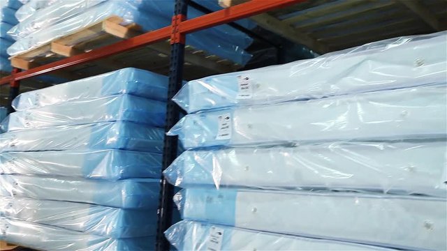 Loading of a warehouse mattresses, orthopedic mattresses on shelves, a warehouse complete set mattresses, an industrial interior, a modern warehouse