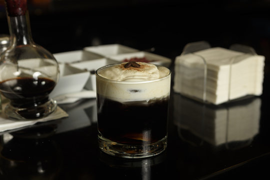 White Russian Cocktail with coffee beans and cinnamon garnished .