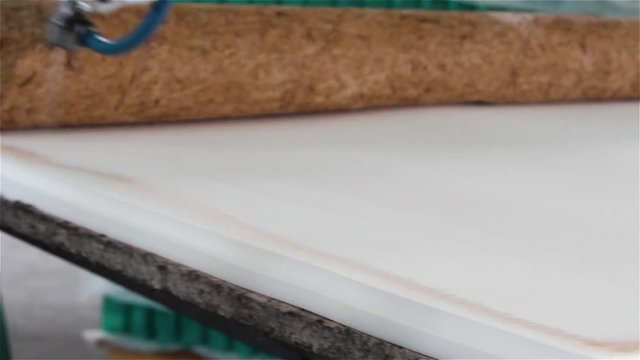 Factory on assembly of orthopedic mattresses, production of mattresses, gluing foam rubber close-up, the worker applies glue on the mattress