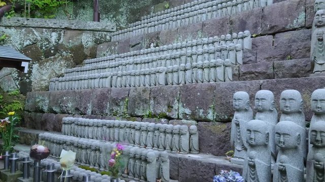Small praying monk statues at Hase Dera Temple in Kamakura - TOKYO / JAPAN - JUNE 12, 2018