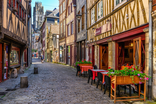 Fototapeta Cozy street with timber framing houses and tables of restaurant in Rouen, Normandy, France