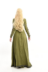 Fototapeta premium full length portrait of blonde girl wearing green medieval gown, standing pose facing away from camera. isolated on white studio background.