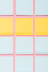Fototapeta premium view from above of blank yellow and blue stick it notes on pink