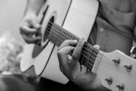 Man Playing Acoustic Guitar in the Outdoor Garden Black and White Color.
